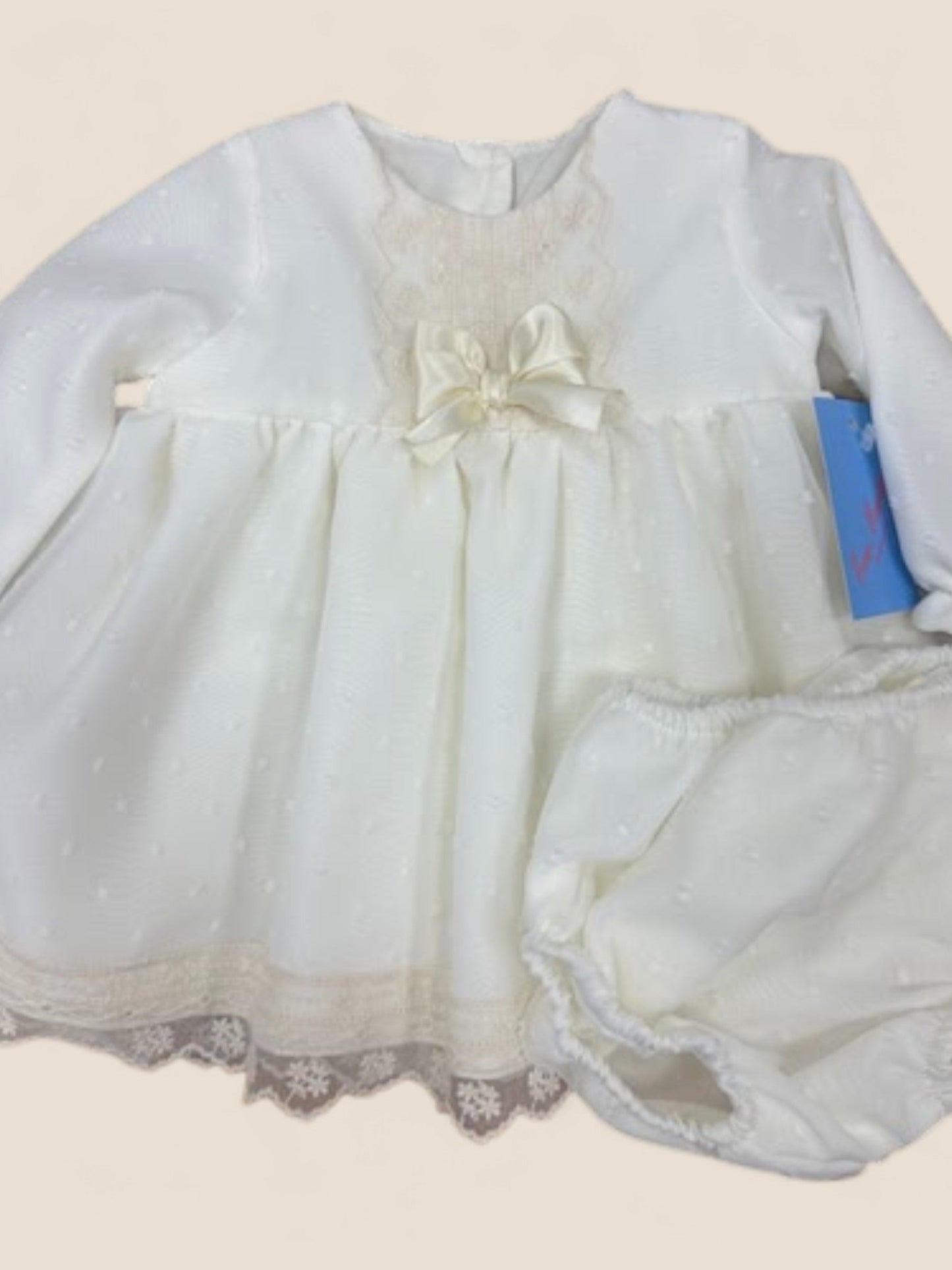 Vestido bebé en plumeti blanco con puntilla y lazo marfil Eva Martinez