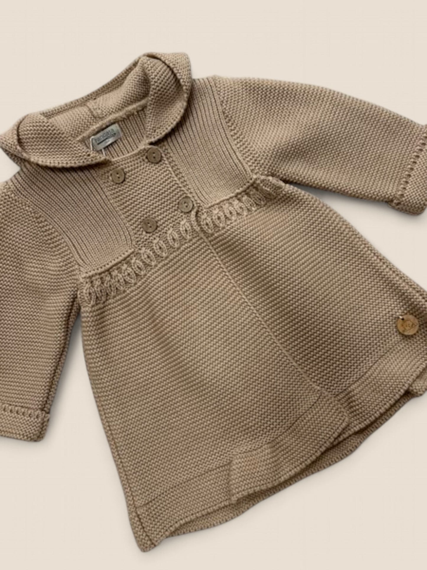 Chaqueta punto tostado con capucha y doble botonadura.