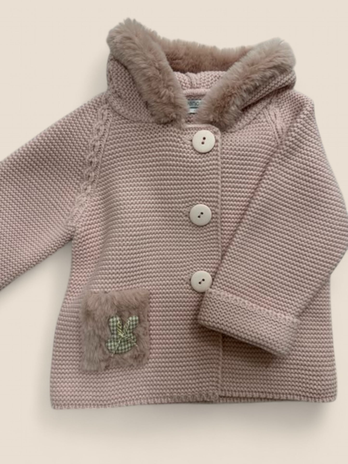 Chaqueta de punto rosa con capucha y conejito bordado.