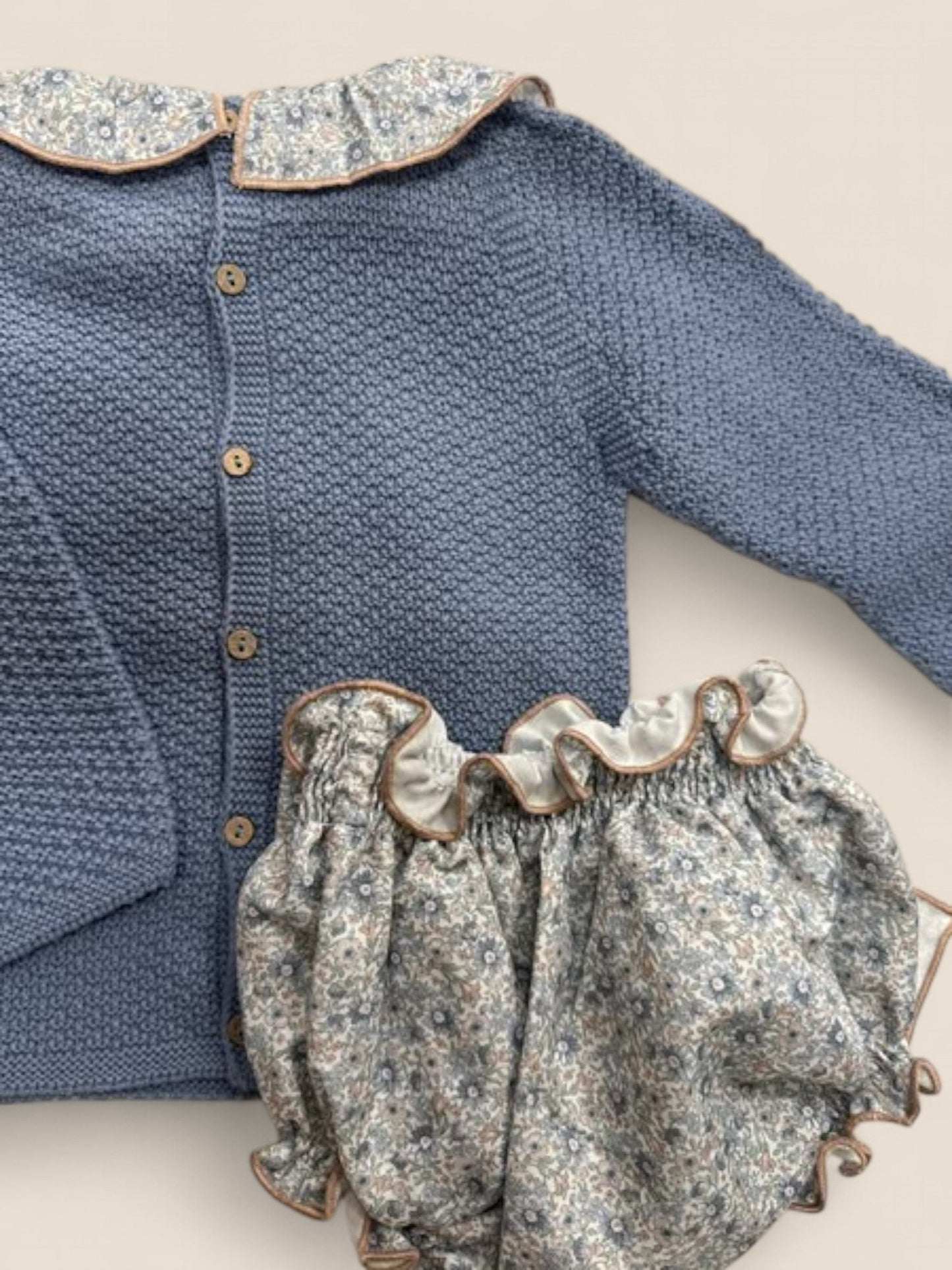 Conjunto azul con cuello volante y braguita lazo flores.
