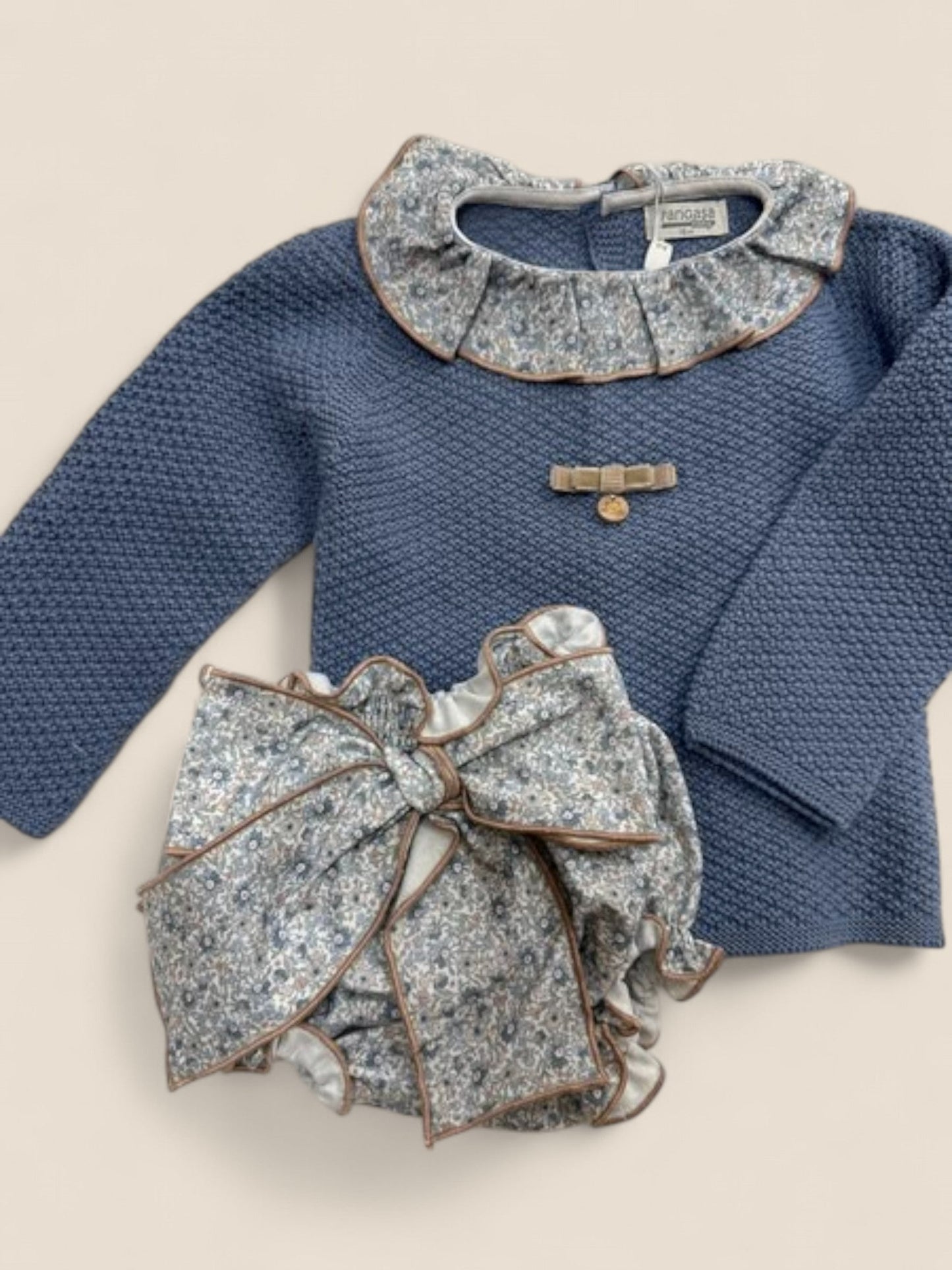 Conjunto azul con cuello volante y braguita lazo flores.