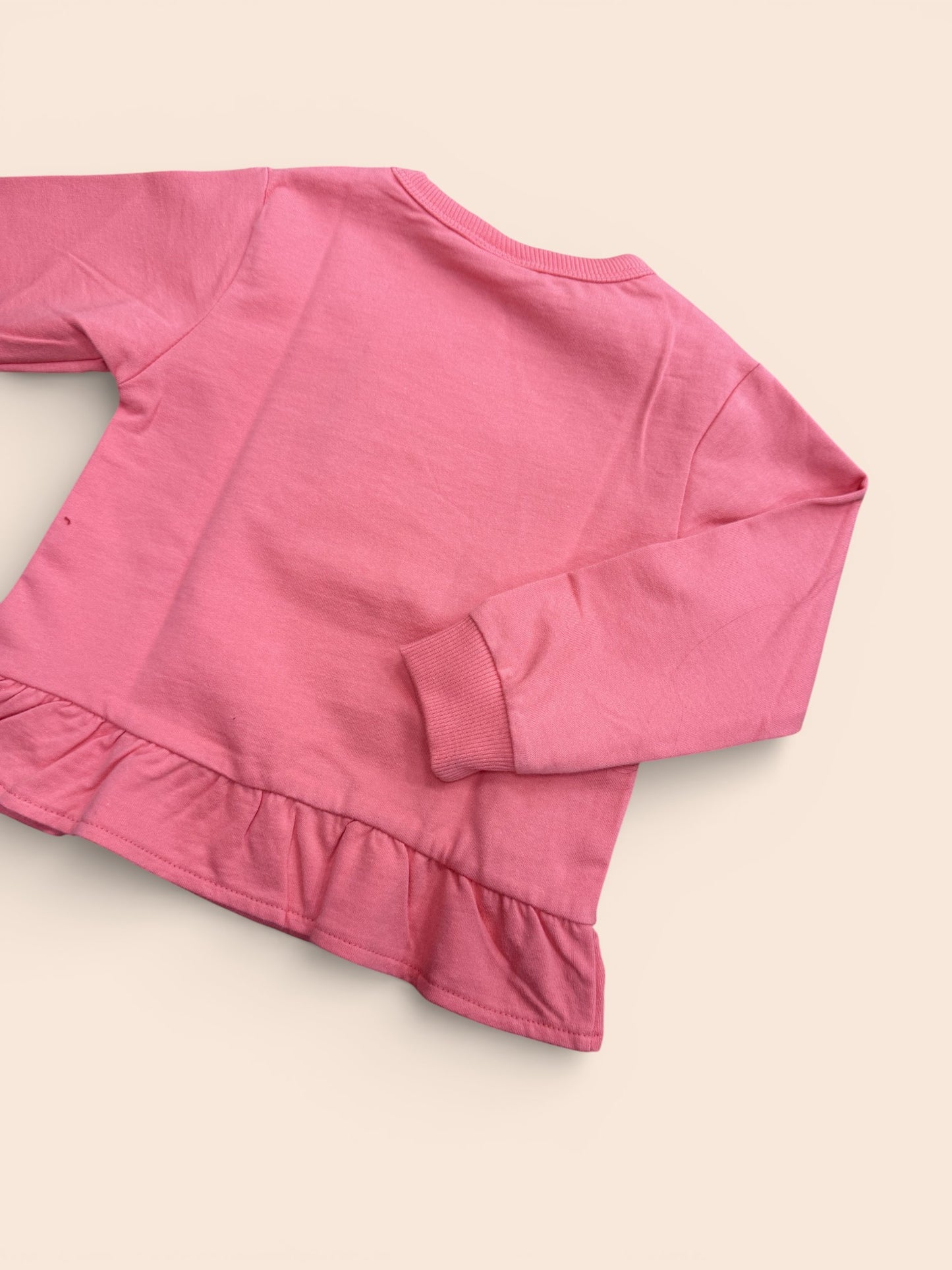 Sudadera rosa con formas geométricas y volante