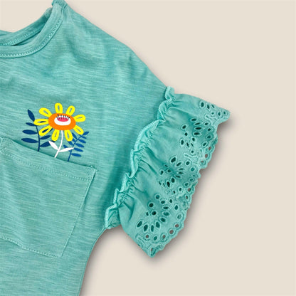 Vestido turquesa con flores y volantes.