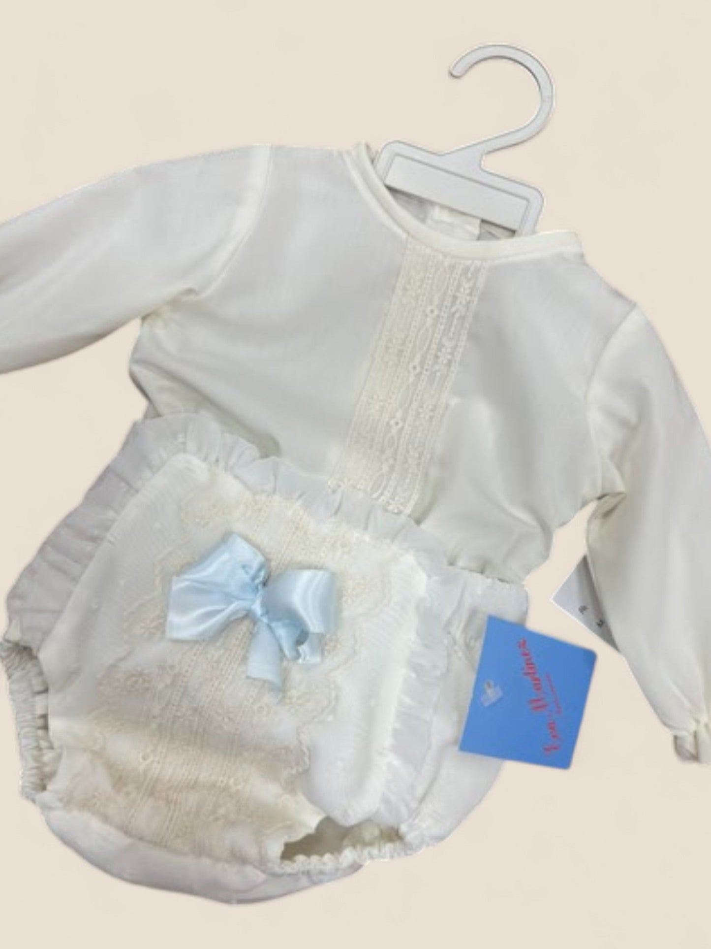 Conjunto bebé en blanco roto con puntilla bordada y lazo azul celeste Eva Martinez