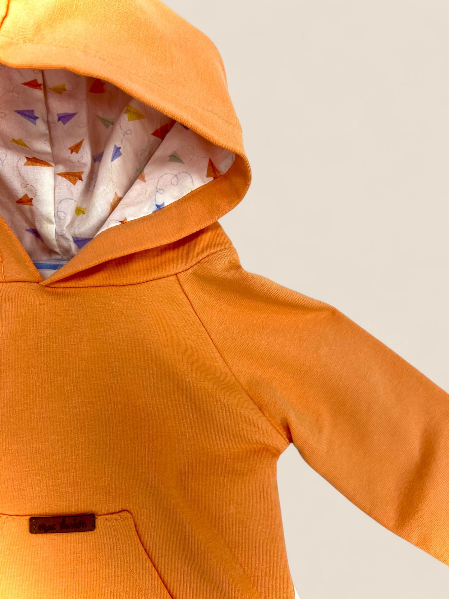 Conjunto sudadera naranja y short blanco.