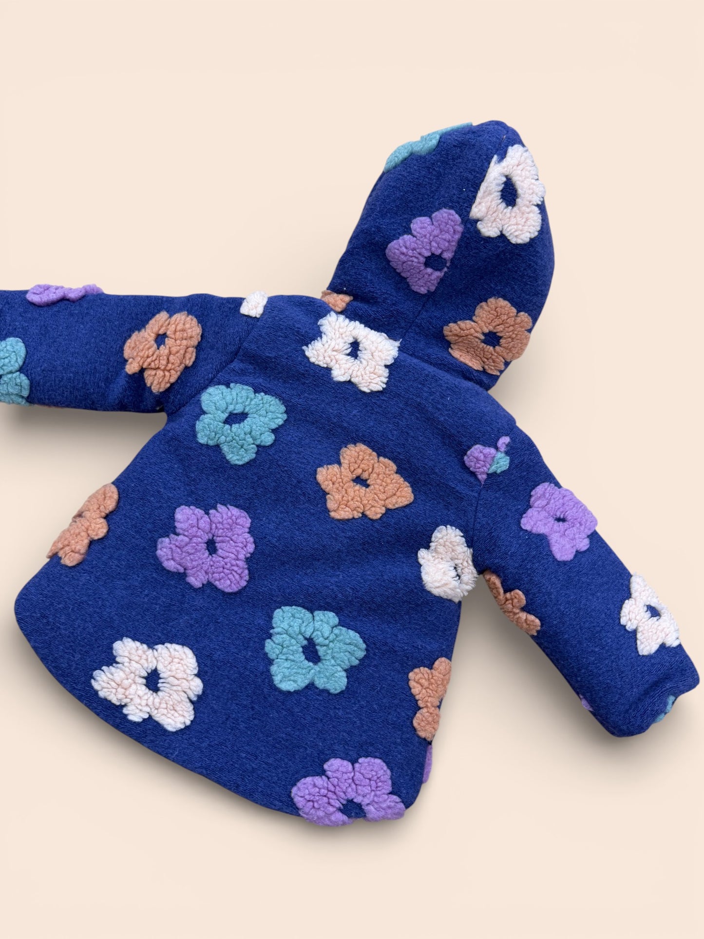Abrigo azul marino de borreguito con flores en relieve y capucha
