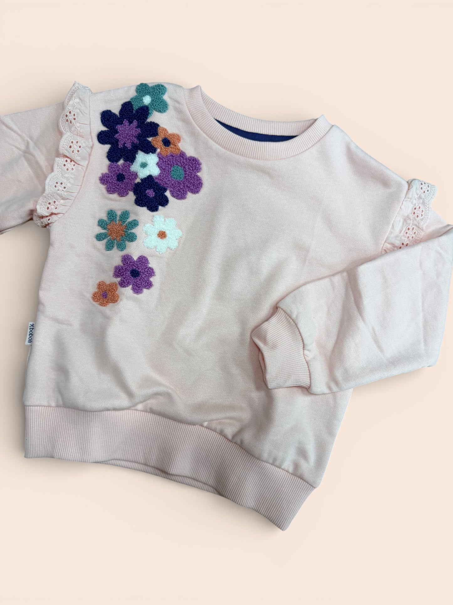 Sudadera rosa con flores bordadas y volante en manga