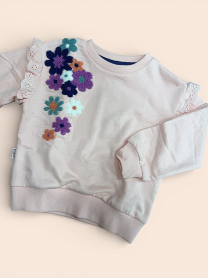 Sudadera rosa con flores bordadas y volante en manga