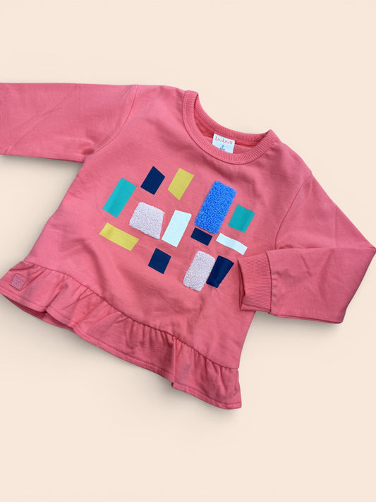 Sudadera  rosa con formas geométricas y volante