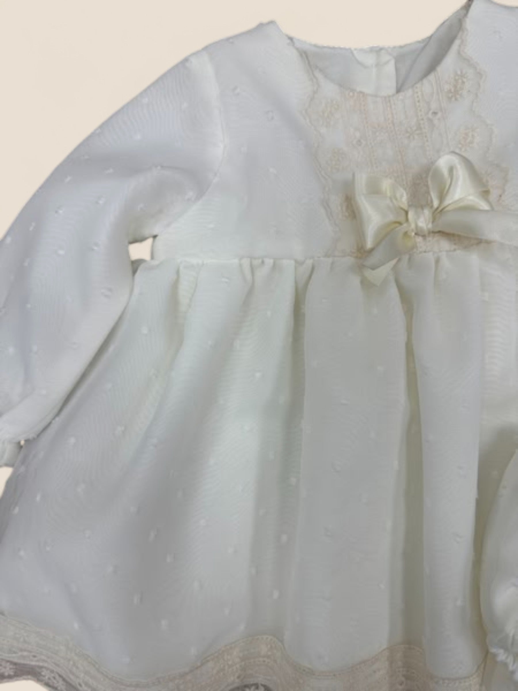 Vestido bebé en plumeti blanco con puntilla y lazo marfil Eva Martinez